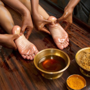 indian doctors doing traditional ayurvedic oil foot massage